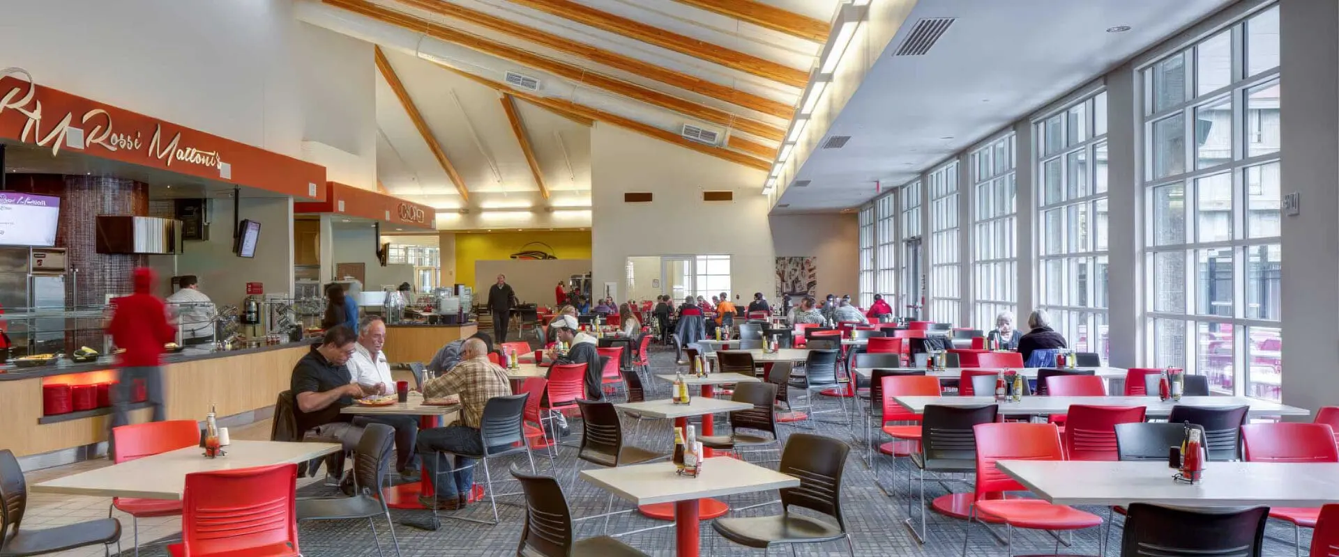 Wide view of The Hawk dining room and serving lines with patrons eating at tables